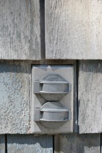 Close up view of siding on house with covered outdoor power outlet