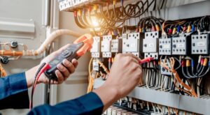 Electrician using multimeter on electrical system