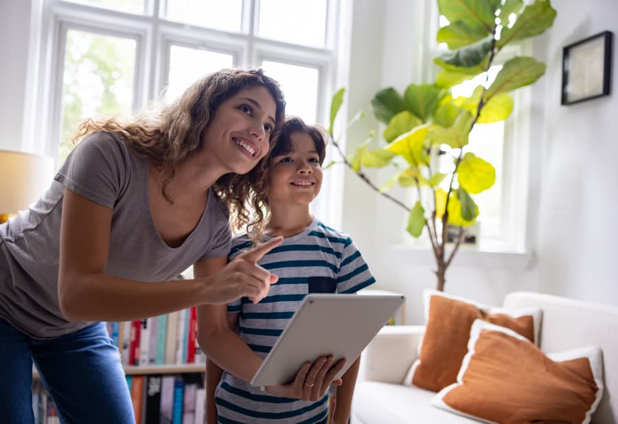 Homeowner and child controlling home with tablet