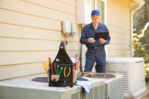 Technician with tablet and tools fixing generator